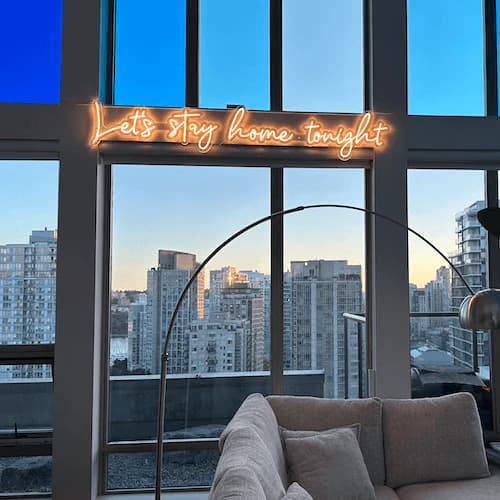 Letrero de neón instalado en ventana con vista a la ciudad